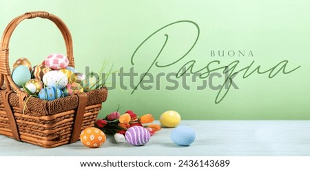 Happy easter in Italian language. Easter painted eggs in the basket on wooden rustic table for your decoration in holiday. Copy space for text.