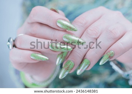 Female hand with long nails and light green manicure