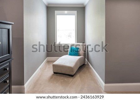 A dormer window inset perfect for a sitting area with a chaise lounge chair to read books or nap. Royalty-Free Stock Photo #2436163929