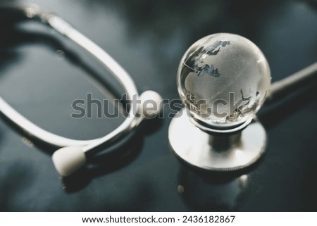 close up glass globe and stethoscope on table, world health day, medical and healthcare, telemedicine and climate change, global pandemic crisis risk and problem concept