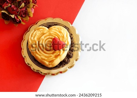 One heart - shaped Valentine's day dessert isolated on red and white background. Valentine's day celebration. Overhead view. Copy space. 