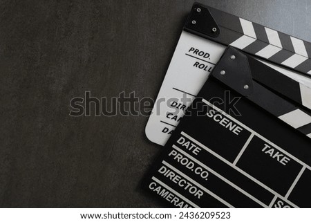movie clapper on black table background ; film, cinema and video photography concept