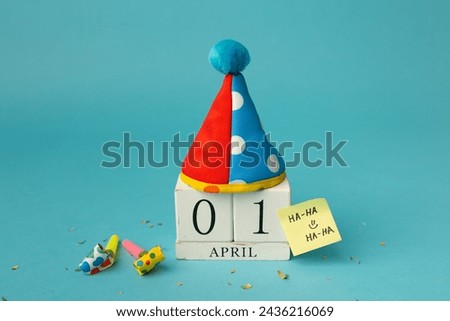 April 1st. Image of april 1 wooden calendar and festive decor on the blue background. April Fool's Day. Royalty-Free Stock Photo #2436216069