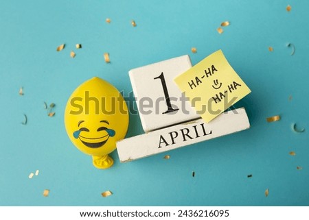 April 1st. Image of april 1 wooden calendar and festive decor on the blue background. April Fool's Day. Royalty-Free Stock Photo #2436216095