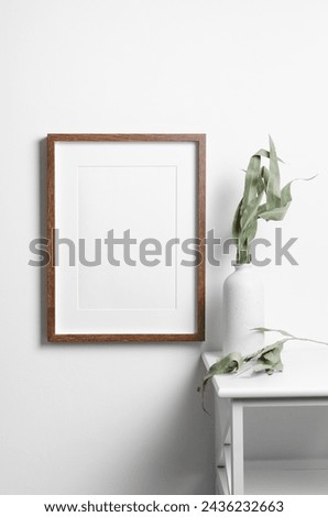 Vertical frame mockup on white wall with interior decorations. Blank mockup with copy space for art, painting or photo