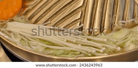 Cook food in a brass pan. Royalty-Free Stock Photo #2436243963