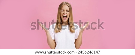 Woman feeling fed up having mental breakdown during deadline yelling with closed eyes, raising hands aside in pissed gesture feeling distressed and pressured losing temper over pink wall. Emotions Royalty-Free Stock Photo #2436246147