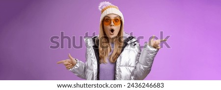 Lifestyle. Impressed blond girl gasping widen eyes surprised folding lips wow sound check out incredible discounts winter equipment pointing left right cannot choose standing astonished purple
