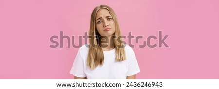 Sad girl whining tilting head raising eyebrows in upset expression and pursing lips feeling disappointed and envy, regretting missed chance standing unhappy and moody over pink background. Emotions
