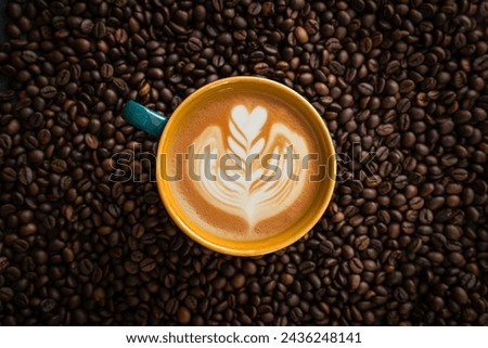 cup of designed Cappuccino isolated on coffee beans background, flatly image of latte art coffee photography