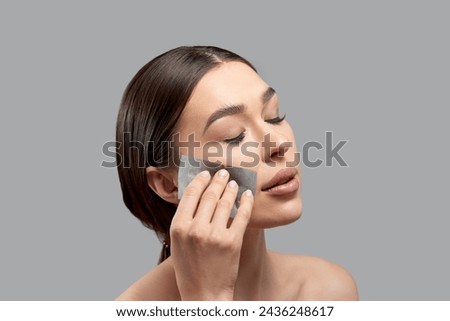 Beautiful attractive woman using Facial oil clean film to removal oil on face for face fresh skin feeling so fresh and clean,Beauty Concept,Isolated on grey background Royalty-Free Stock Photo #2436248617