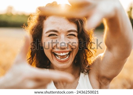 Close up of smiling woman making frame gesture with hands 