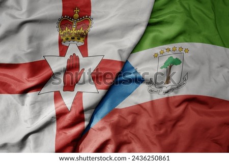 big waving national colorful flag of equatorial guinea and national flag of northern ireland . macro