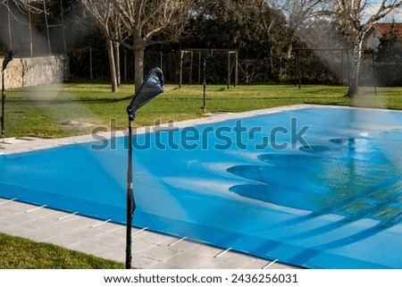 Swimming pool covered with a blue tarp ready to spend the winter Royalty-Free Stock Photo #2436256031