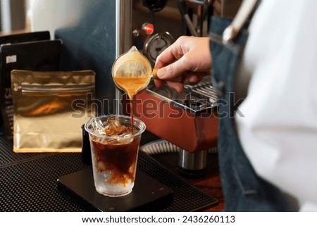 Hands of multiethnic men employee barista businessman business owner small cafe shop Pouring coffee into  clear glass intently At the coffee maker counter Family business minimalist style