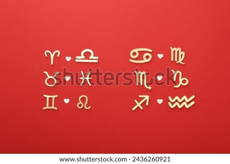 Zodiac signs compatibility on red background, flat lay Royalty-Free Stock Photo #2436260921