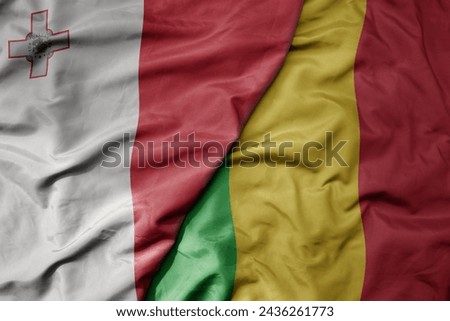 big waving national colorful flag of mali and national flag of malta. macro