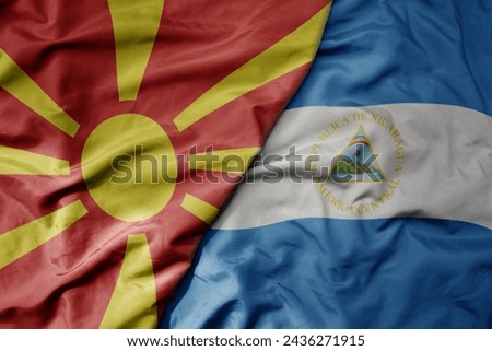 big waving national colorful flag of nicaragua and national flag of macedonia . macro