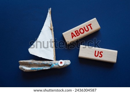 About us symbol. Concept word About us on wooden blocks. Beautiful deep blue background with boat. Business and About us concept. Copy space