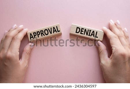 Approval or Denial symbol. Concept word Approval or Denial on wooden blocks. Businessman hand. Beautiful pink background. Business and Approval or Denial concept. Copy space Royalty-Free Stock Photo #2436304597