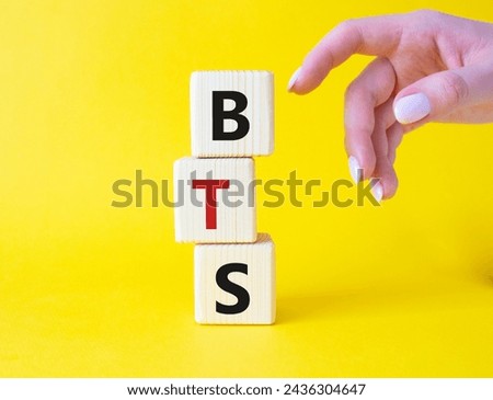 BTS symbol. Wooden cubes with word BTS. Businessman hand Beautiful yellow background. BTS concept. Copy space.