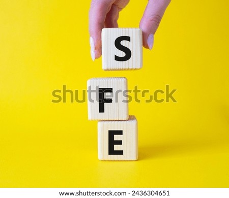 SFE - Sales Force Effectiveness. Wooden cubes with word SFE. Businessman hand. Beautiful yellow background. Business and Sales Force Effectiveness concept. Copy space.