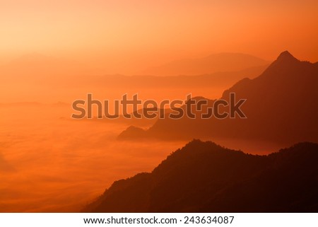 White mist floating among mountains in orange tone