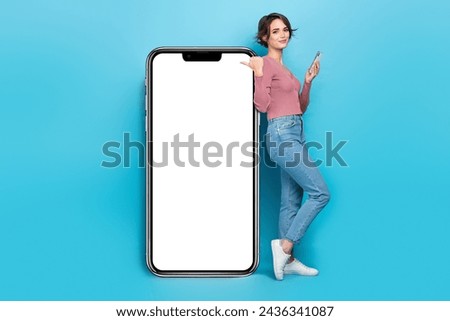 Full size photo of clever woman wear pink cardigan hold smartphone directing at ui panel touchscreen isolated on teal color background