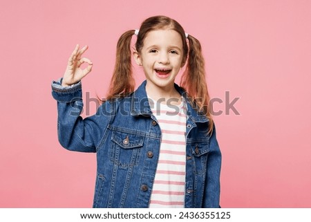 Little child satisfied smiling cute kid girl 7-8 years old wears denim shirt have fun showing ok okay gesture isolated on plain pastel light pink background. Mother's Day love family lifestyle concept