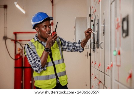 Electrical engineer working in control room. Electrical engineer man checking Power Distribution Cabinet in the control room Royalty-Free Stock Photo #2436363559