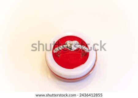 Picture of a ring kept in a box with a white background. Silver, golden, platinum, fashion, chain, jewelry, girl, women, indian, asian, price, fall, stock, market, symbol, love, gift, engagement.