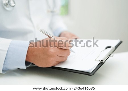 Asian man doctor study document to research method and technic for treating patients. Royalty-Free Stock Photo #2436416595