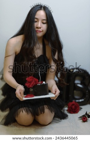 Beautiful woman wearing a black dress and chocolate cake in the concept of birthday