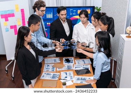 Multiethnic business people holding jigsaw pieces and merge them together as effective solution solving teamwork, shared vision and common goal combining diverse talent. Meticulous Royalty-Free Stock Photo #2436452233