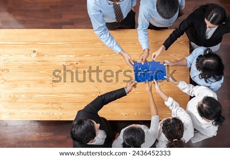 Multiethnic business people holding jigsaw pieces and merge them together as effective solution solving teamwork, shared vision and common goal combining diverse talent. Panorama top view. Meticulous Royalty-Free Stock Photo #2436452333
