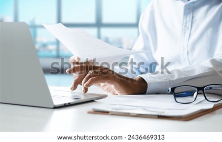 Asian businessman working in office checking document report, business contract and using laptop meeting online with business partners