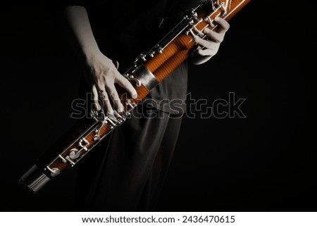 Bassoon woodwind instrument with player hands. Orchestra musical instruments close up Royalty-Free Stock Photo #2436470615