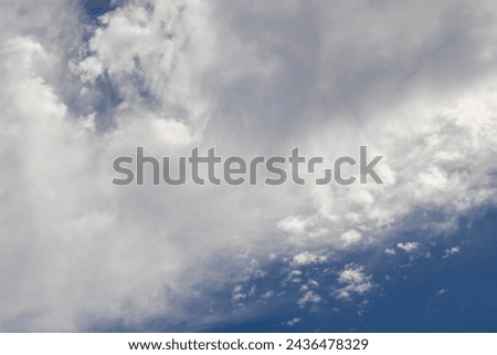 Fluffy white cumulus clouds with some cumulostratus formations on a late summer afternoon are contrasted against the azure blue Australian sky.  Royalty-Free Stock Photo #2436478329