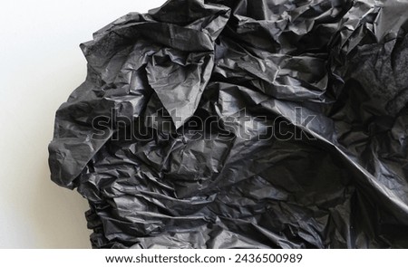 A Crushed Wadded Up Sheet Of Black Paper On White Background. Stock Photo For Paper Design Concept 