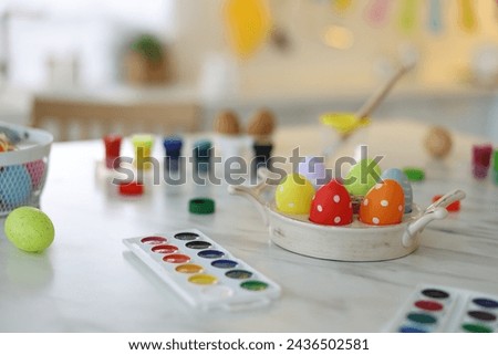 Happy Easter. Painted eggs and watercolor on white marble table indoors