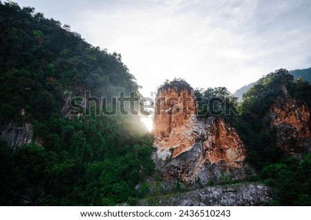 Morning sun light shine through mountain in Kin Loong Valley, Ipoh, Perak, Malaysia. Royalty-Free Stock Photo #2436510243