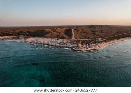 Aerial picture of a sunset over the lighthouse in Exmouth, Western Australia. Beach and ocean view from the sky. Transparent water. Ningaloo reef, Australia.