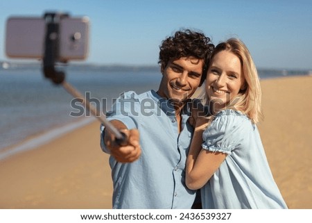 young couple taking vacation selfie photograph at the beach