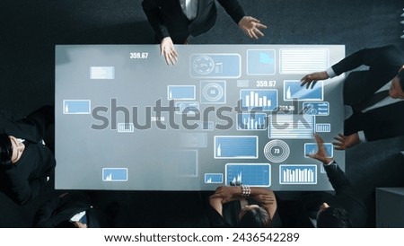 Top down aerial of collaborate professional diverse business people discuss marketing strategy with hologram of marketing data analysis graph, diagram or financial profit investment plan. Directorate.