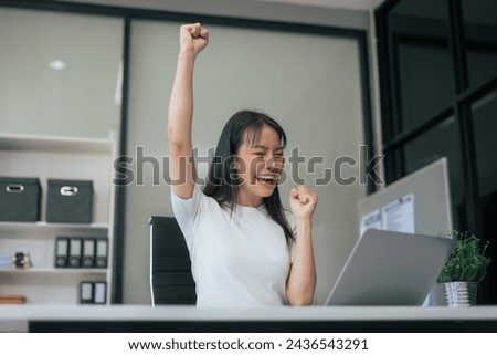 Overjoyed charming excited asian business woman worker using laptop working in office, feeling happy.