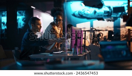 Portrait of Black Creative Director Giving Instructions on 3D Game Visuals to Male Developer in Creative Agency. Two Stylish Diverse Employees Discussing Design on Computer in Game Development Company Royalty-Free Stock Photo #2436547453