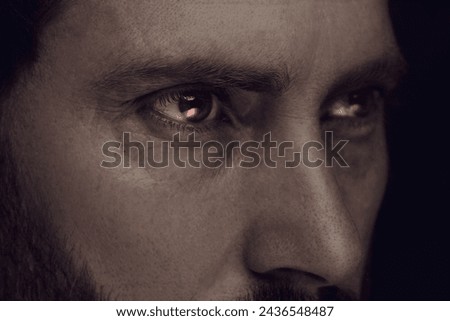 Evil eye. Man with red demonic eyes, closeup