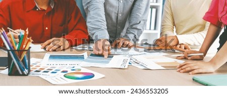 A cropped image of professional interior designer discuss the color material with her colleagues by comparing with color swatches and color palette document. Creative design concept. Variegated.