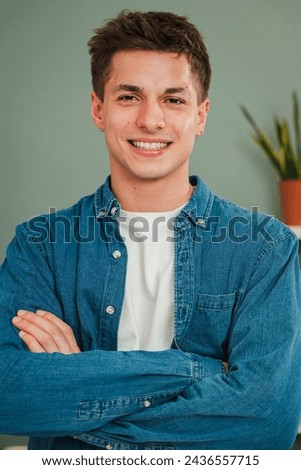 Vertical individual portrait of one young adult caucasian guy smiling and looking at camera with friendly expression. Headshot of a real teenage man student with white teeth staring front at home Royalty-Free Stock Photo #2436557715
