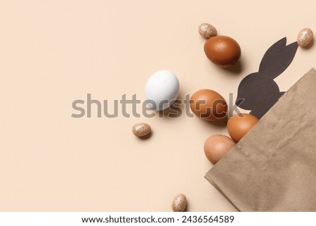 Shopping bag with paper Easter bunny and eggs on beige background